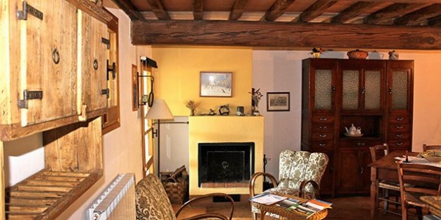 Wohnraum mit Kamin Tischen und Stühlen